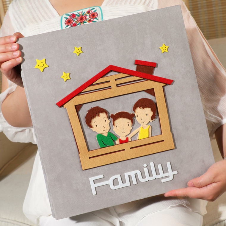 Copertina album colore grigio, disegno casetta con famiglia, decorazioni con stelle