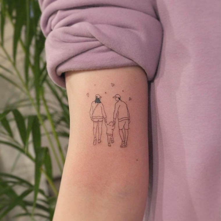 Tatuaggio sul braccio di una donna, disegno di una famiglia, simboli tattoo 