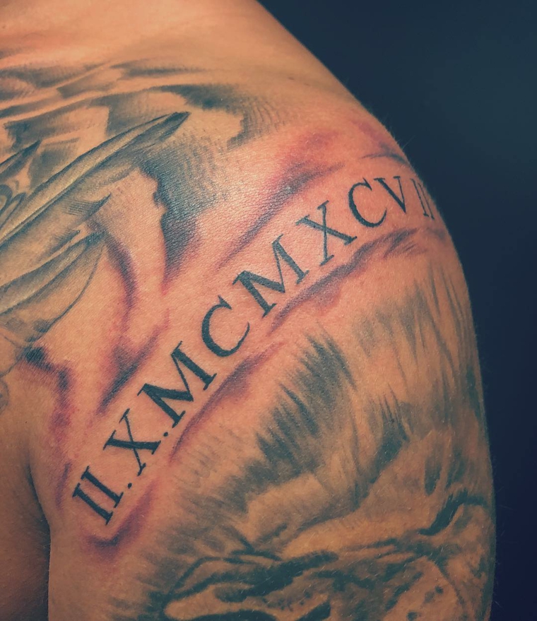 Tattoo numeri romani, tatuaggio sulla spalla, uomo con tatuaggi sul braccio