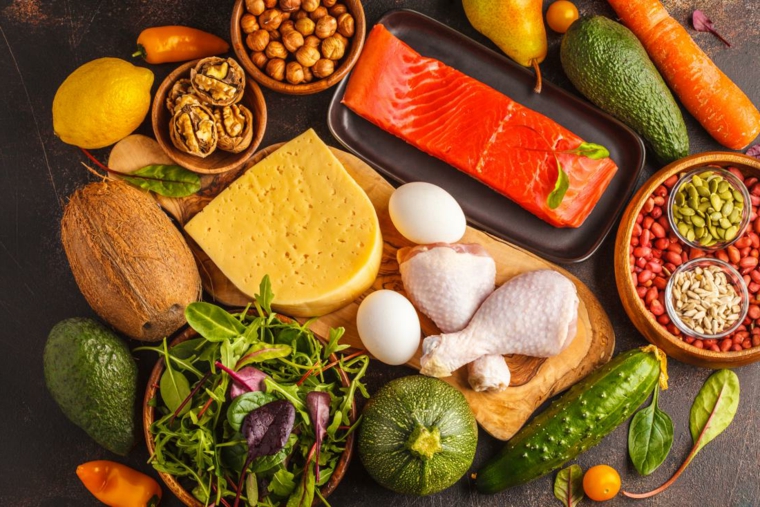 Filetto di salmone, ciotole con frutta a guscio, verdure e lattuga, esempio dieta chetogenica