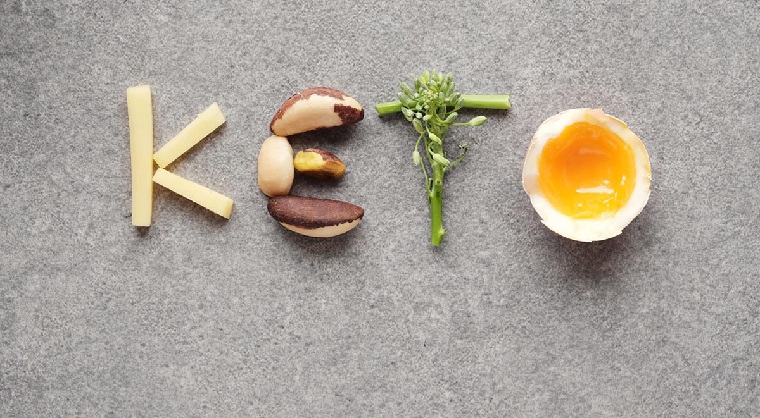Dieta chetogenica, scritta Keto con alimenti, uovo sodo tagliato, pezzettini di formaggio