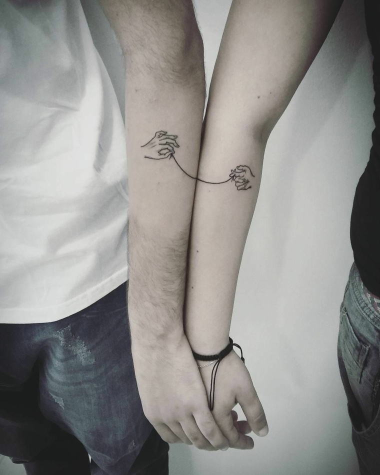 Catalogo tatuaggi, disegno mani e filo che unisce, tatuaggi sull'avambraccio, tattoo piccolo per lui 