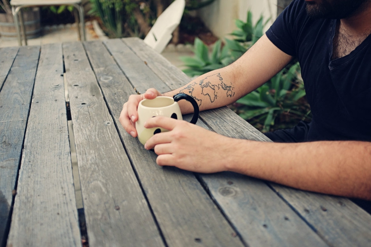 Tavolo di legno per giardino, tattoo sul braccio uomo, tatuaggi significato libertà