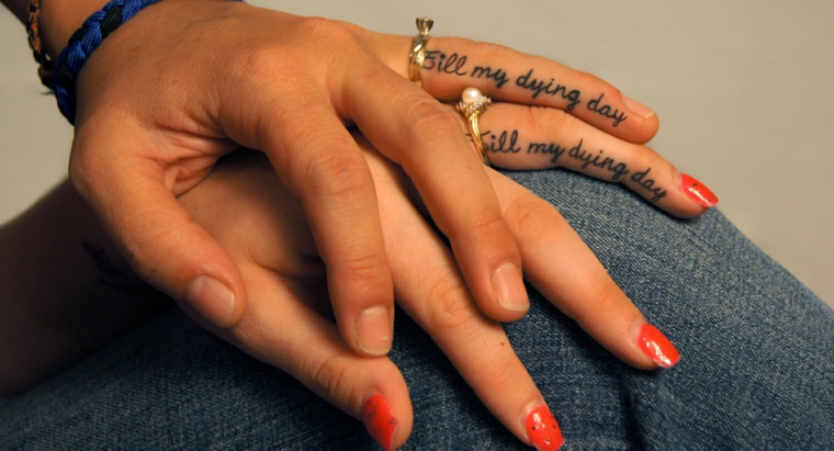 Tattoo sulle dita, tatuaggi di coppia, anelli con pietre, smalto arancione nail art