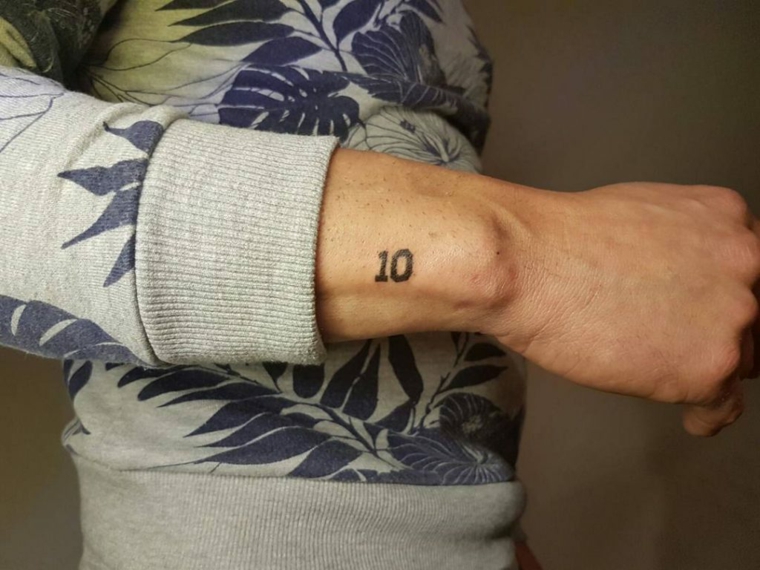 Uomo con tattoo sul polso, disegno tattoo numero , uomo con maglione grigio