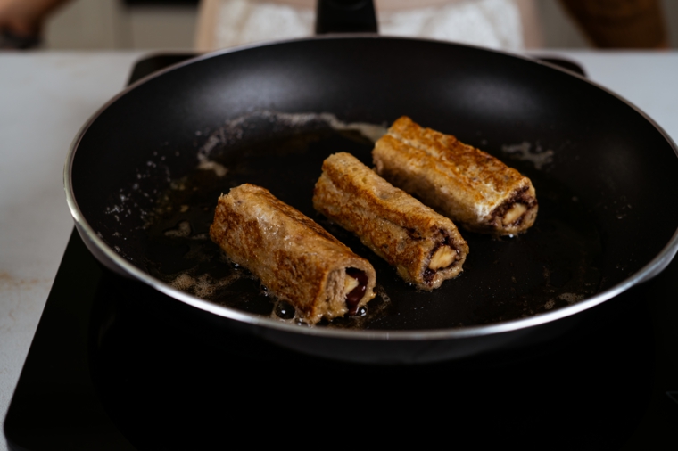 Ricetta per french toast, padella con burro e involtini fritti alla banana e cioccolato
