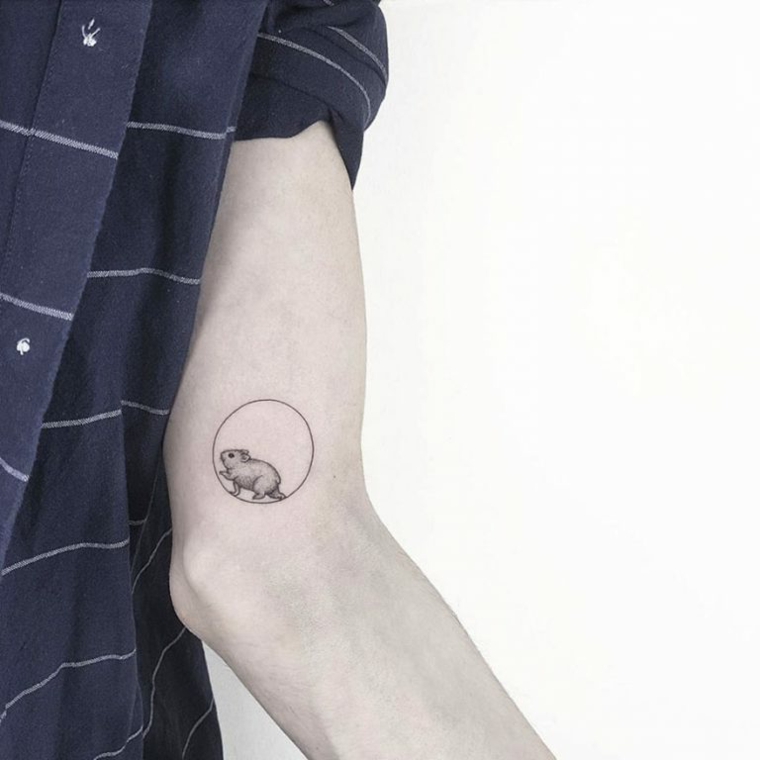 Uomo con tattoo sul braccio, disegno topino in un cerchio, uomo con camicia a quadri