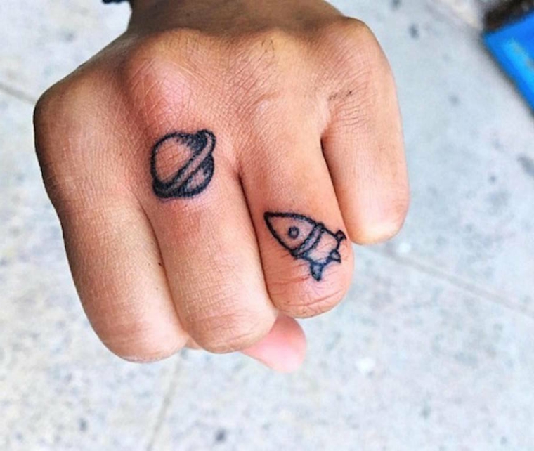 Tatuaggio sulle dita, disegno pianeta sul dito, uomo con tatuaggi discreti
