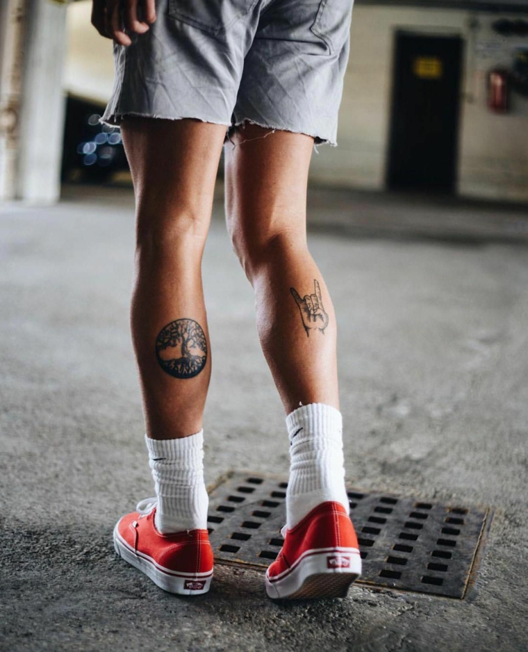 Uomo con tatuaggi sul polpaccio, disegno natura sul tattoo, tatuaggi piccoli maschili
