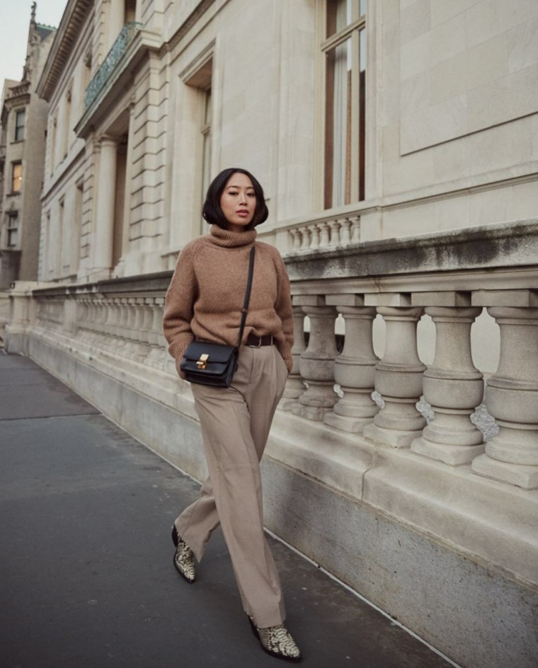 Outfit inverno 2019, donna che cammina per strada, pantalone largo colore grigio, borsa nera tracolla