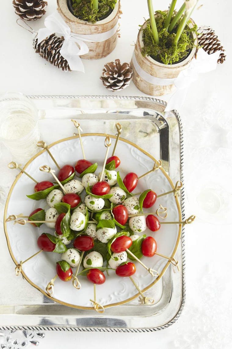 Antipasti per la viglia di Natale, stuzzichini con pomodorini, mozzarella e foglie di basilico