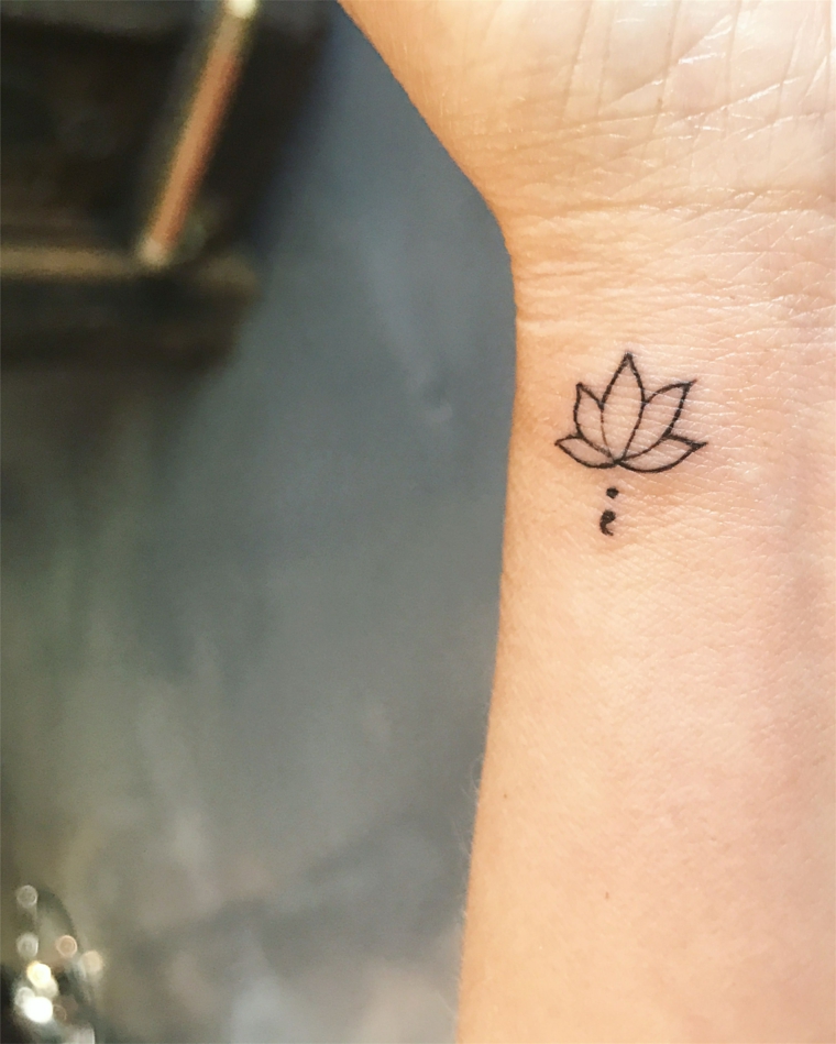 Tattoo fiore di loto, tatuaggio sul polso della mano, disegno tatuaggio con punto e virgola 
