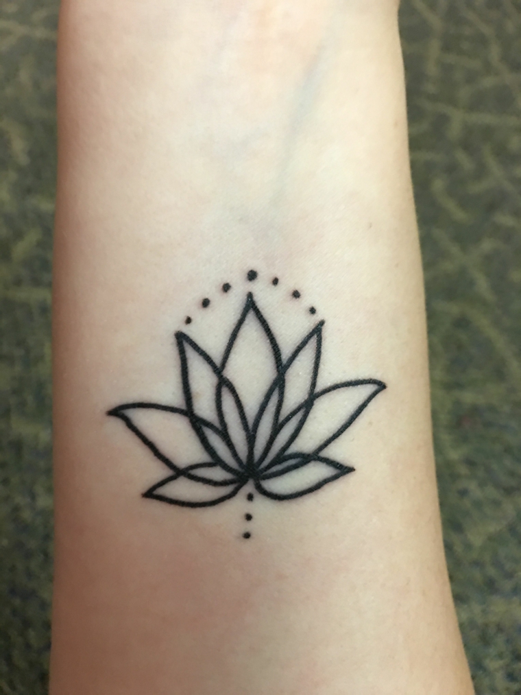 Fiore di loto significato, tatuaggio sull'avambraccio di una donna, disegno simboli del mandala