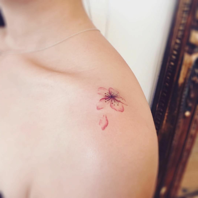 Fiore di loto mandala, tatuaggio colorato sulla spala, piccolo fiore rosa sulla spalla di una donna