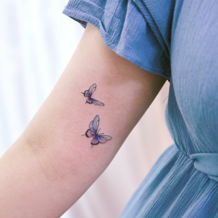 Disegni farfalle colorate, braccio di una donna con tattoo di farfalle colorate