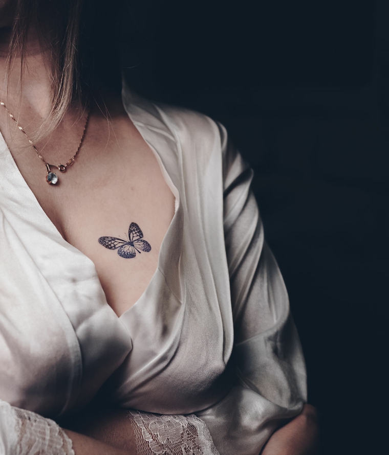 Farfalla tattoo, disegno minimal di una farfalla, tatuaggio sul corpo di una donna