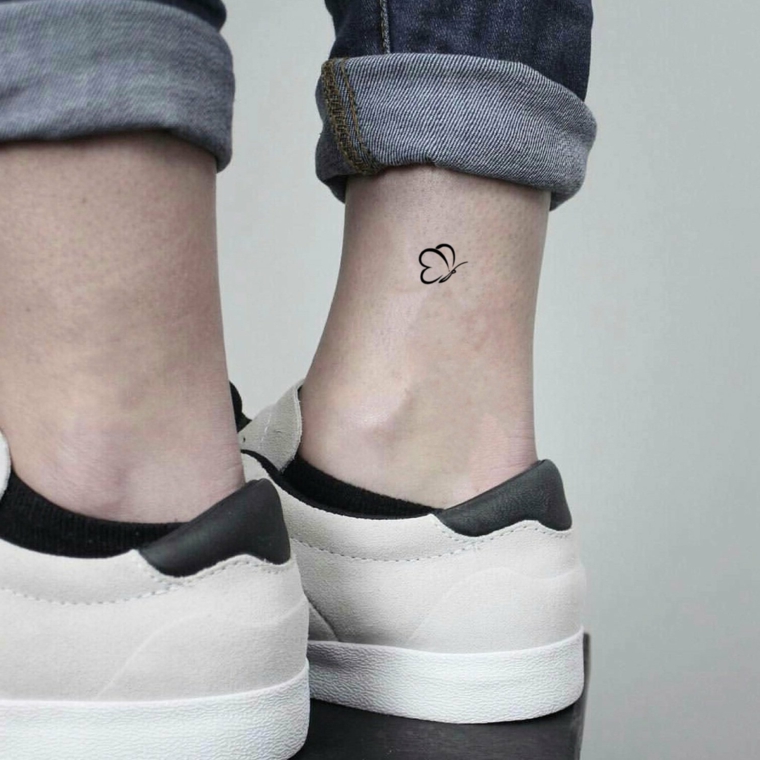 Farfalla significato, disegno tattoo sulla caviglia di una donna, ragazza con jeans