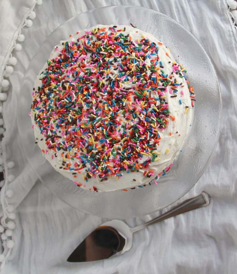 Torte bellissime, torta decorata con codette di zucchero colorati, strato superiore della torta con panna montata