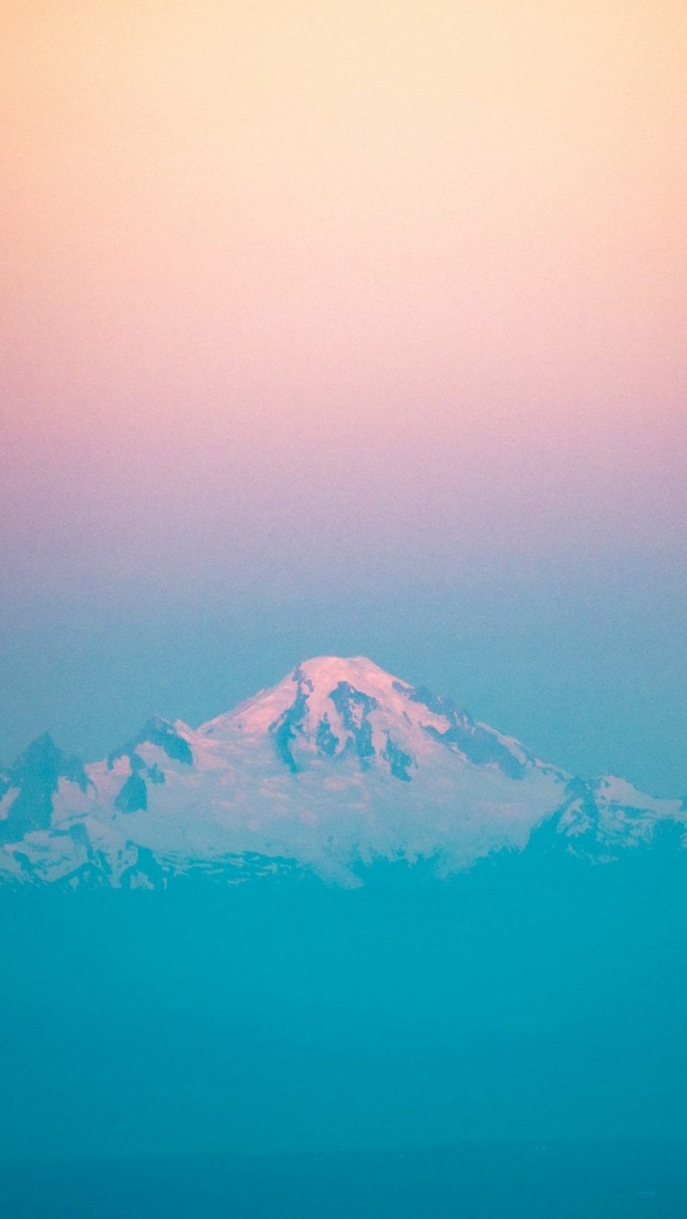 Sfondi bellissimi, foto di una montagna innevata con nubi di colore azzurro e rosa