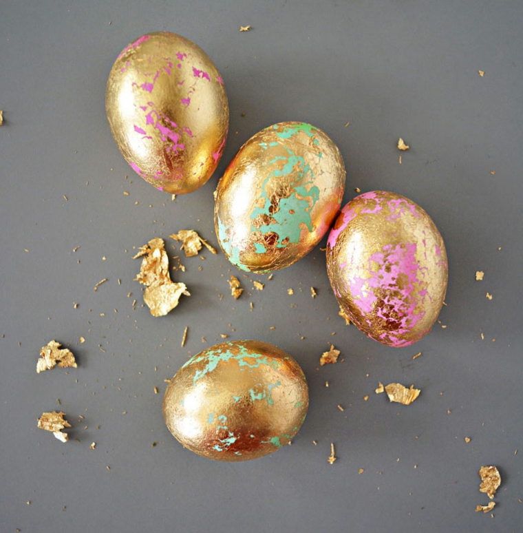 Frasi auguri di Pasqua simpatici, foto di uova colorate di oro su sfondo grigio