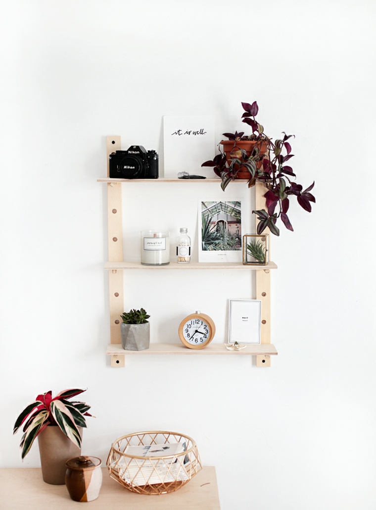 Mobili da appendere al muro, libreria con mensole, fotografie e vasi con piante