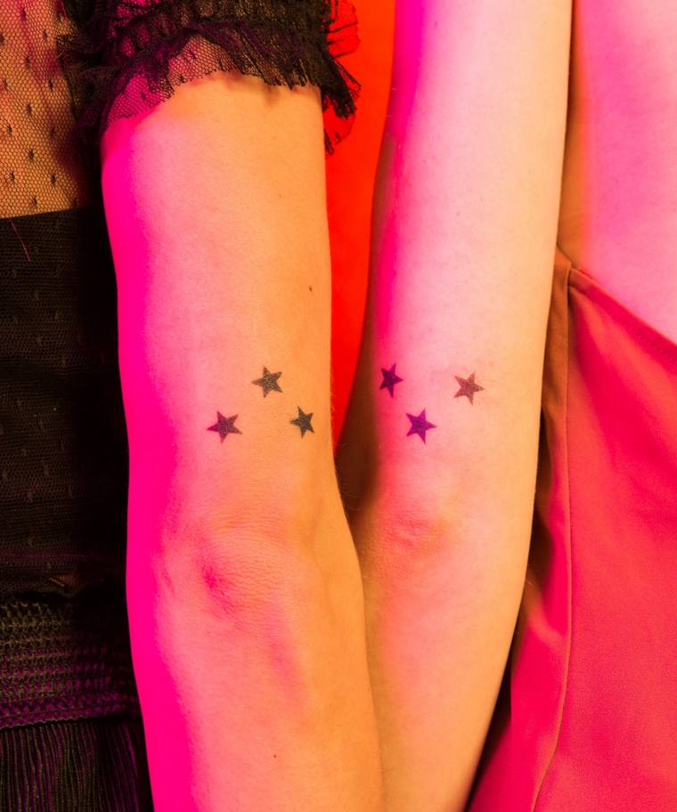 Tatuaggi sorelle, tattoo sul braccio di due ragazze con disegno di stelle