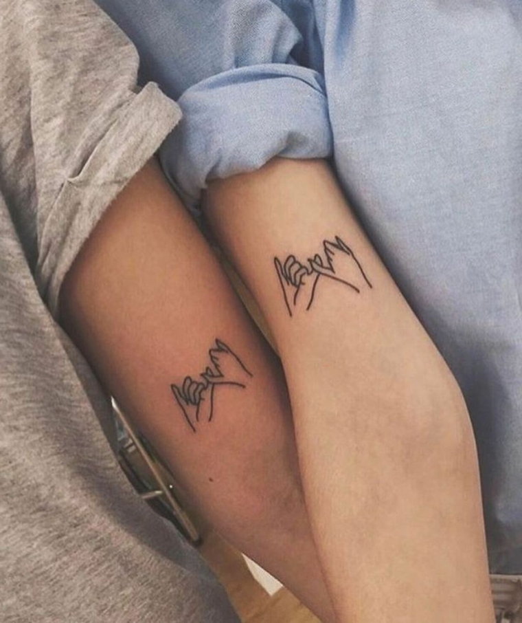 Tatuaggio migliore amica, tattoo con disegno mani unite sull'avambraccio di due donne