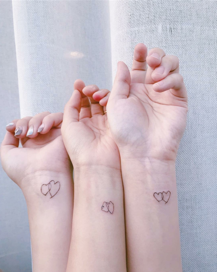 Tatuaggi sorelle, tattoo sul polso della mano con disegni di cuori