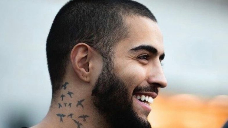 Uomo con tatuaggi rondini sul collo, taglio capelli uomo corti, viso di profilo con barba