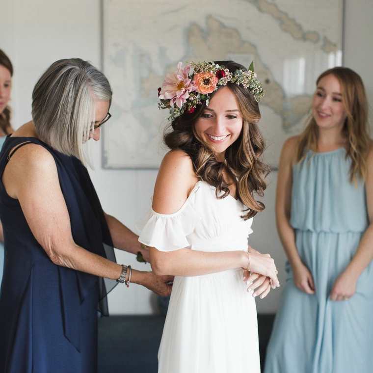 Acconciature sposa 2020 semiraccolto, donna con capelli castani ricci e corona di fiori