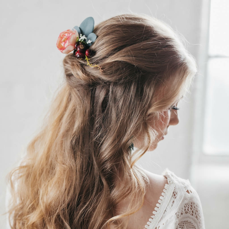 Acconciature capelli lunghi semiraccolto, ragazza con capelli biondi mossi con molletta di fiori