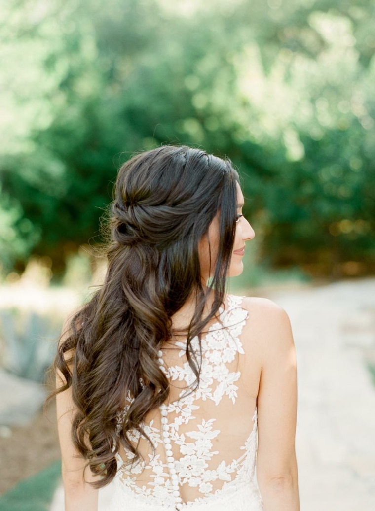 Ragazza con capelli castani lunghi e mossi, pettinatura da sposa con semiraccolto