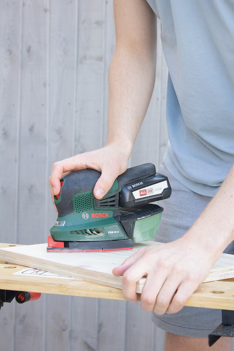 Invenzioni con il legno, uomo che lavora un pannello di legno con la smerigliatrice