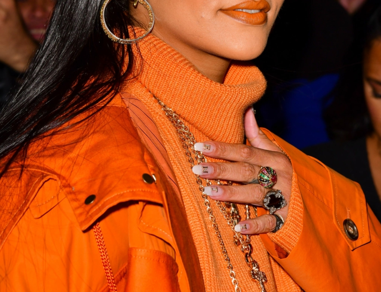 colori smalto inverno 2020 unghie con scritte e french manicure donna con giacca arancione