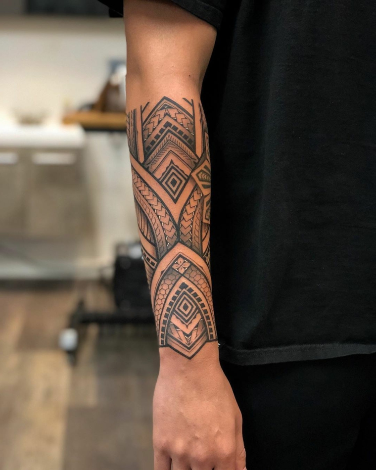 tattoo a fascia sul braccio di un uomo tatuaggio con motivi maori