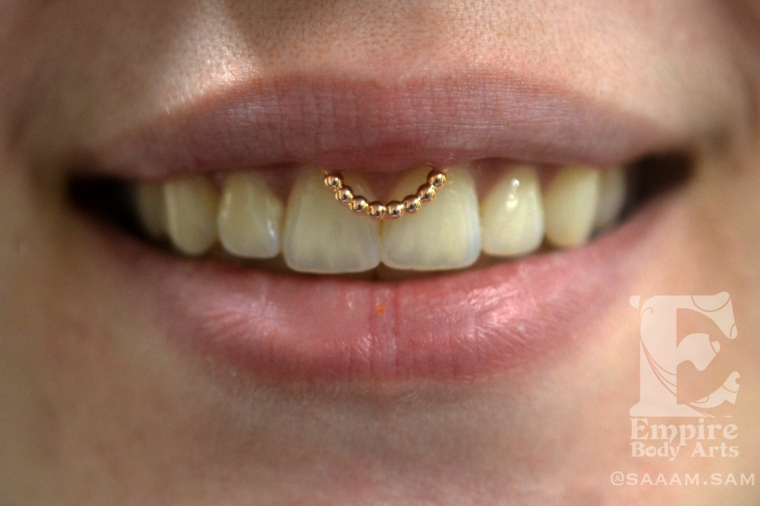 viso e labbra di una ragazza piercing al frenulo donna con denti bianchi