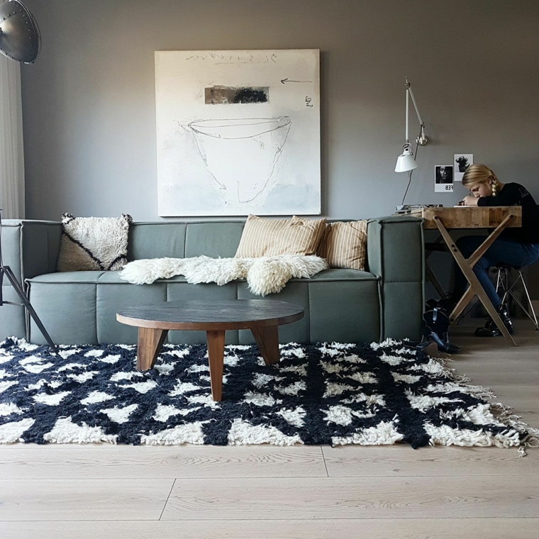 soggiorno stile nordico divano in tessuto tavolino di legno rotondo pavimento con tappeto