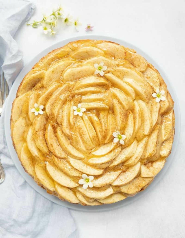 torta rotonda decorata con fette di mele sotto gelatina decorazione con fiori