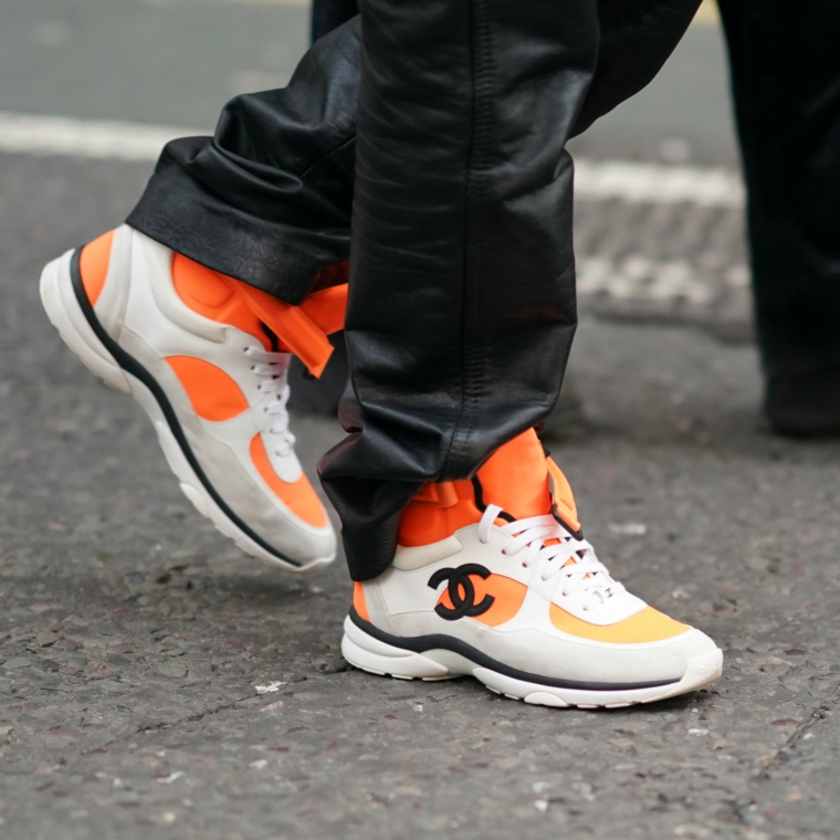 sneaker di moda uomo scarpe chanel di colore arancione abbinamento pantalone grigio