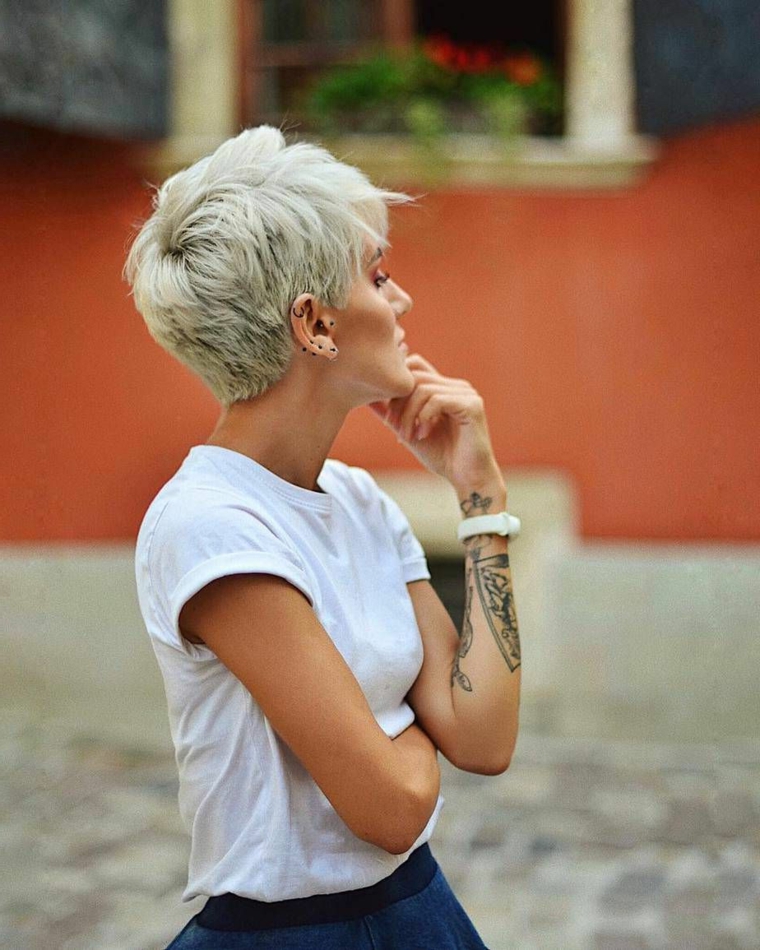 donna con tatuaggio sull avambraccio acconciatura capelli biondi taglio pixie