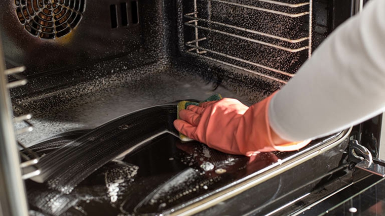 pulire il forno con detersivo per piatti e spugna utilizzare guanti di gomma