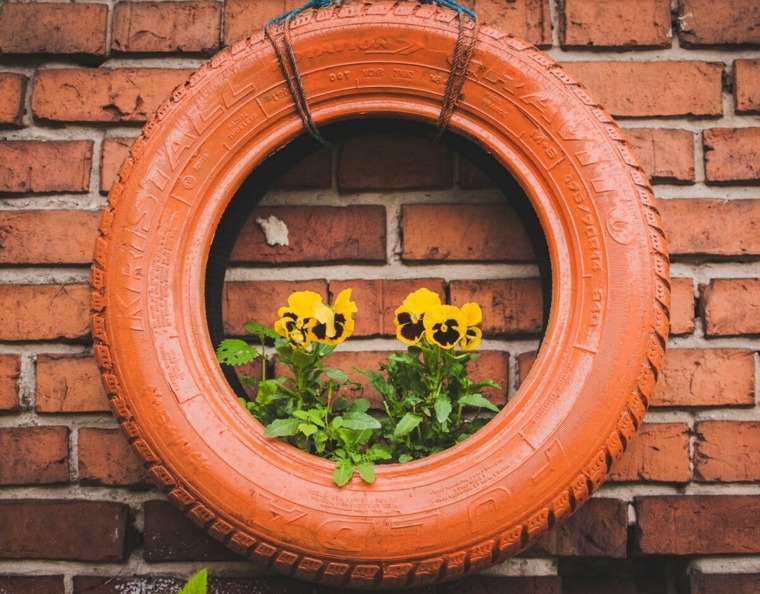 decorazione parete con pneumatico trasformato in vaso per fiori