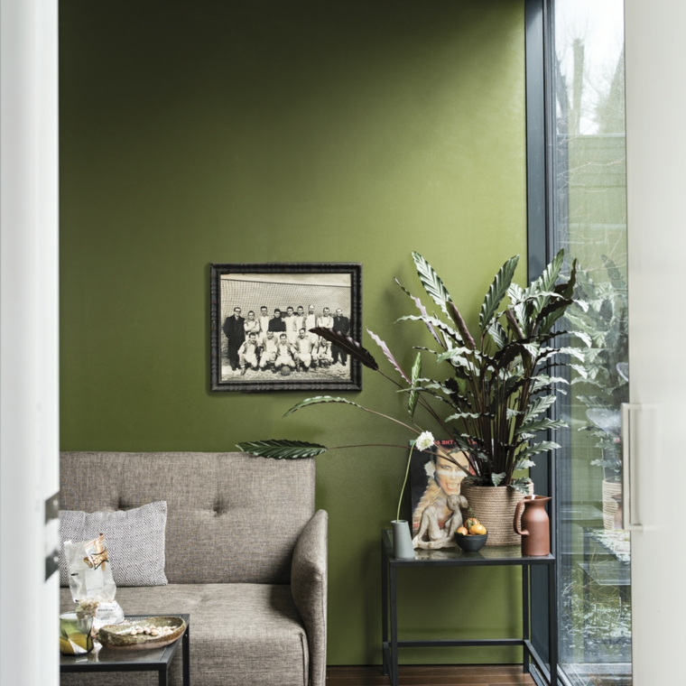 tonalità di verde per pareti interne salotto con divano grigio decorazioni con piante