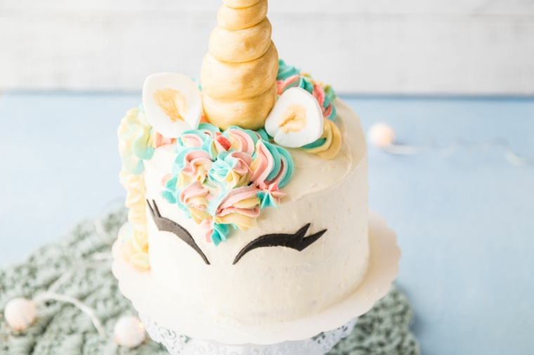 torta unicorno con fiori di panna colorata glassa di colore bianco