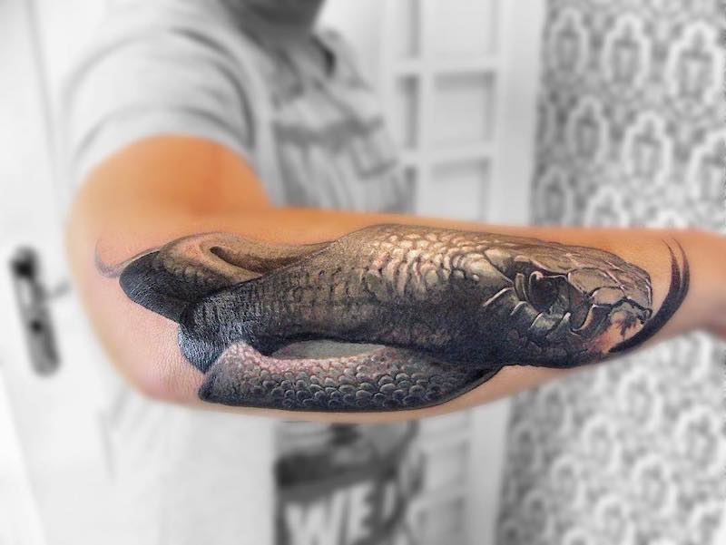 tattoo realistico di un serpente sul braccio