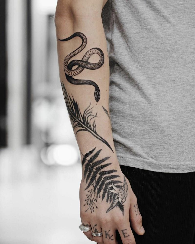 tatuaggio serpente donna avambraccio con disegni floreali