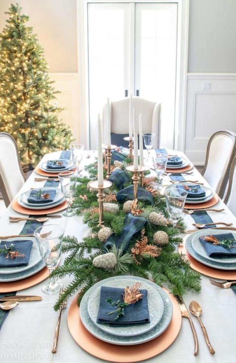 tavola natalizia decorata con rami e pigne