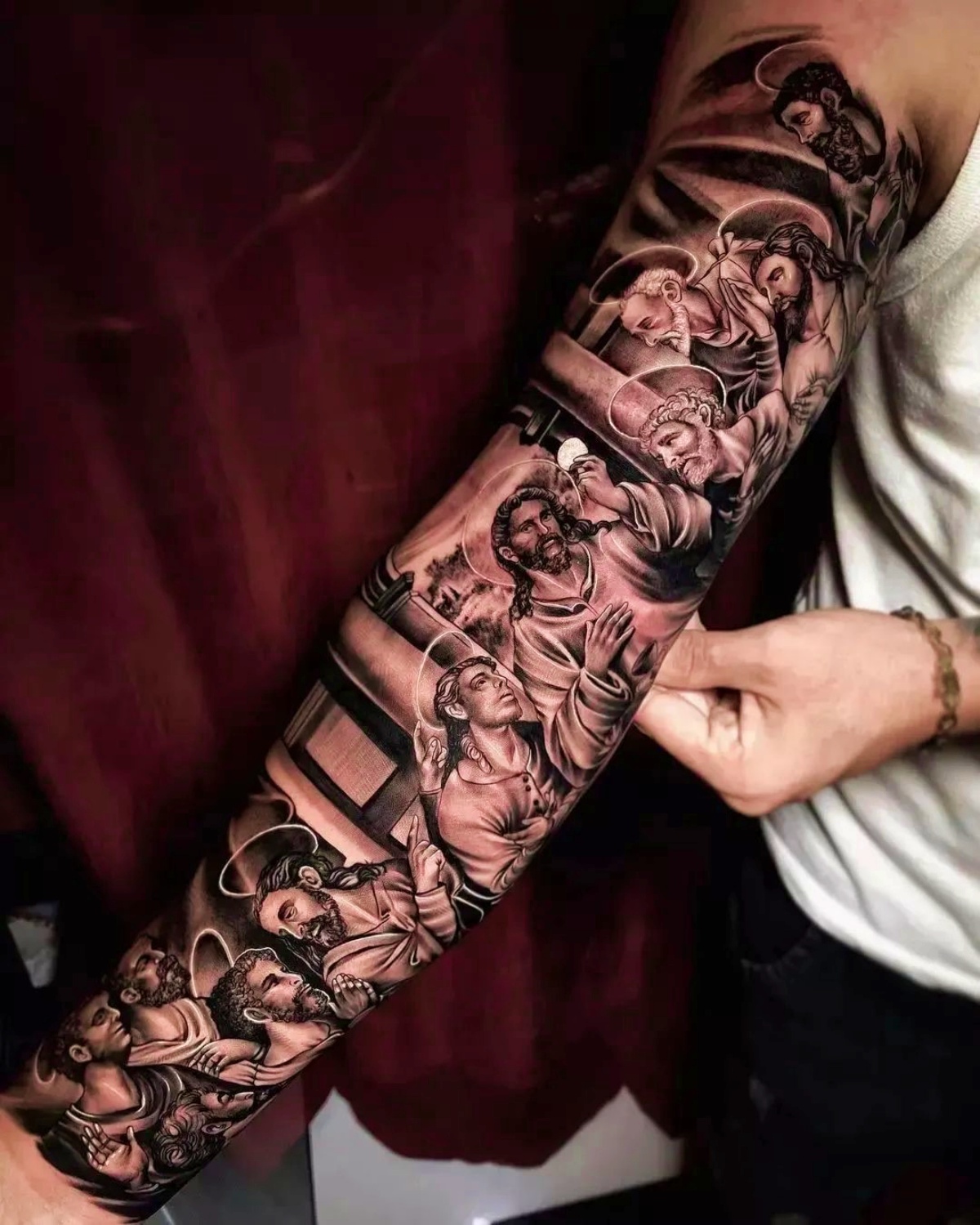 tatuaggio religioso sul braccio di un uomo