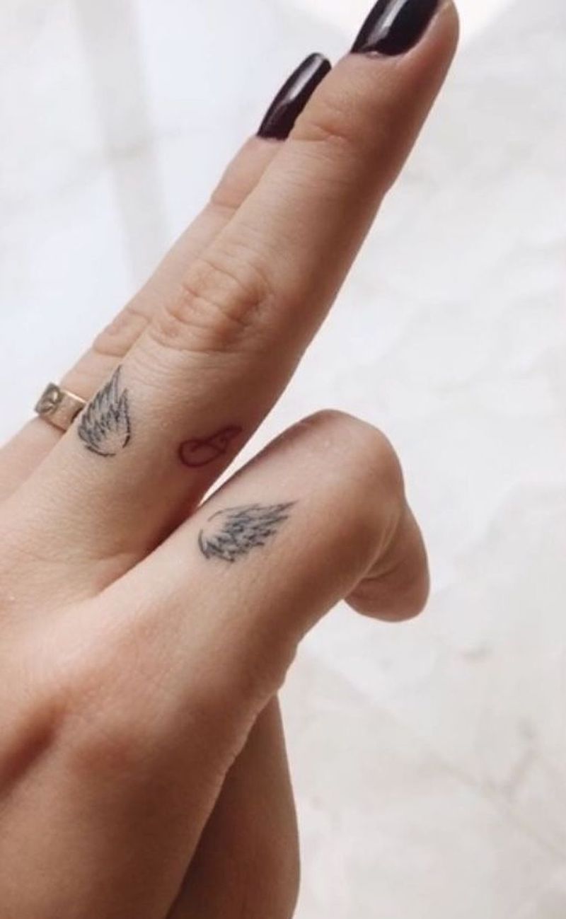 tatuaggio piccolo con disegno di ali sulle dita