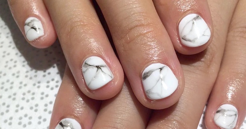 unghie corte con smalto bianco marmo
